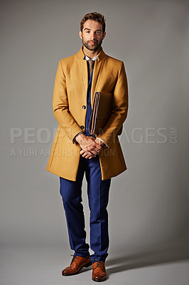 Buy stock photo Studio portrait of a handsome young businessman posing against a dark background