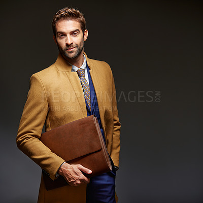 Buy stock photo Studio portrait of a handsome young businessman posing against a dark background