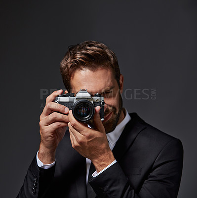 Buy stock photo Studio portrait of a handsome young man taking pictures against a grey background