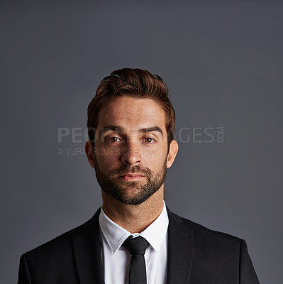 Buy stock photo Studio portrait of a handsome young businessman posing against a grey background