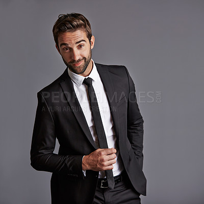 Buy stock photo Studio portrait of a handsome young businessman posing against a grey background