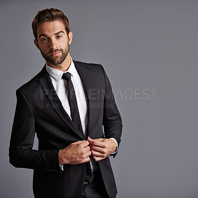 Buy stock photo Studio portrait of a handsome young businessman posing against a grey background