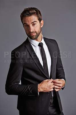 Buy stock photo Studio portrait of a handsome young businessman posing against a grey background