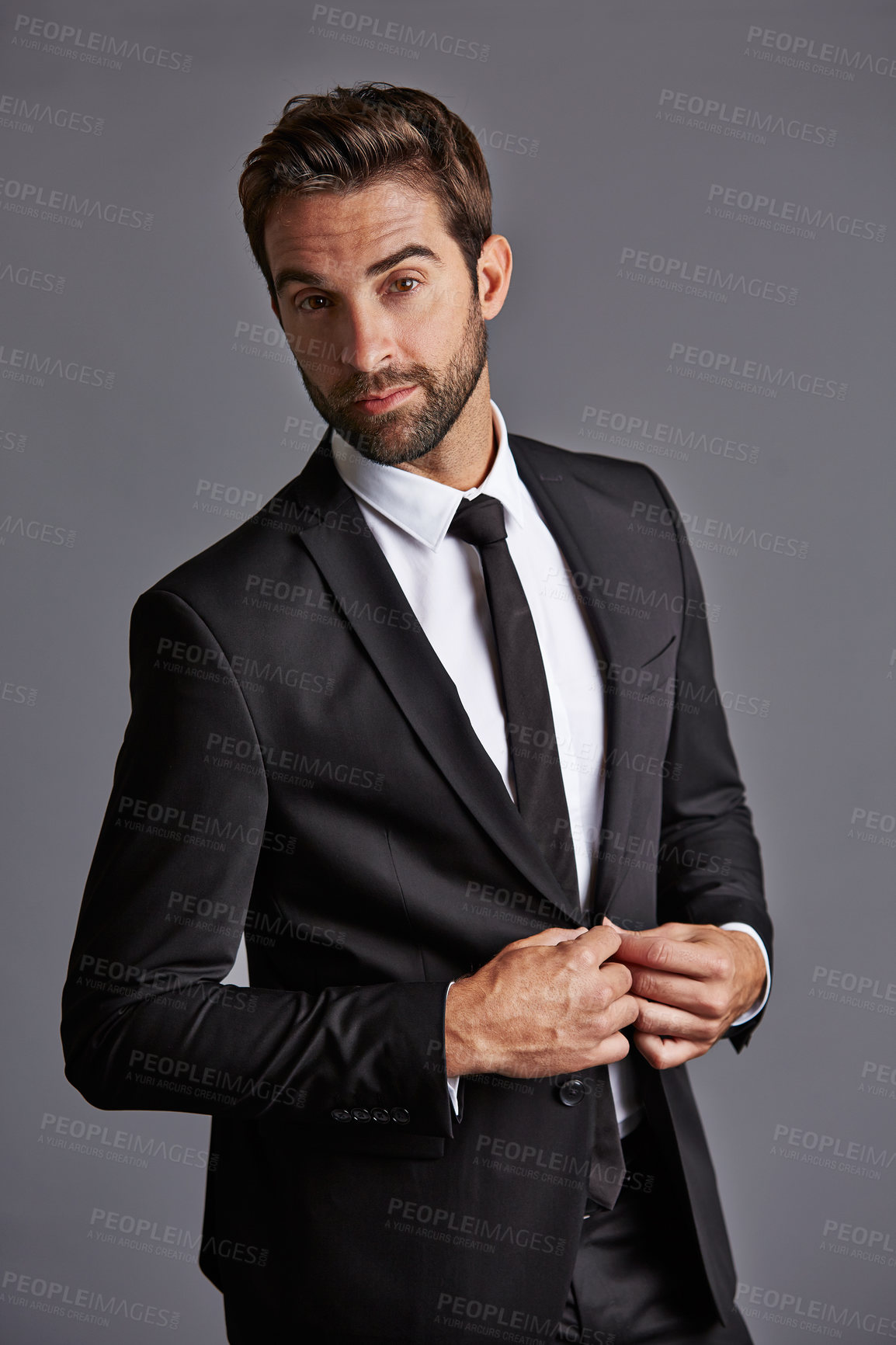Buy stock photo Studio portrait of a handsome young businessman posing against a grey background