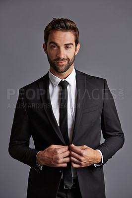 Buy stock photo Studio portrait of a handsome young businessman posing against a grey background