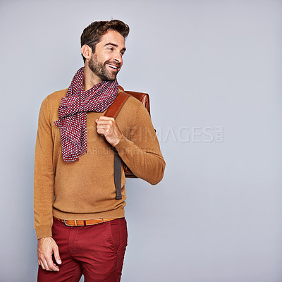 Buy stock photo Studio shot of a handsome young man carrying a backpack against a grey background