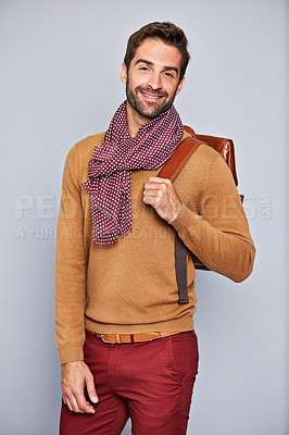 Buy stock photo Studio portrait of a handsome young man carrying a backpack against a grey background