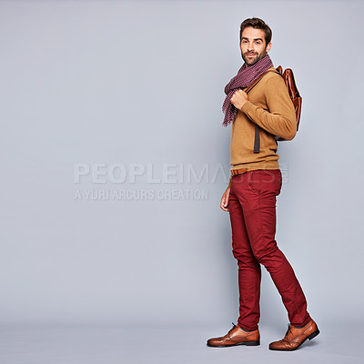 Buy stock photo Studio portrait of a handsome young man carrying a backpack against a grey background