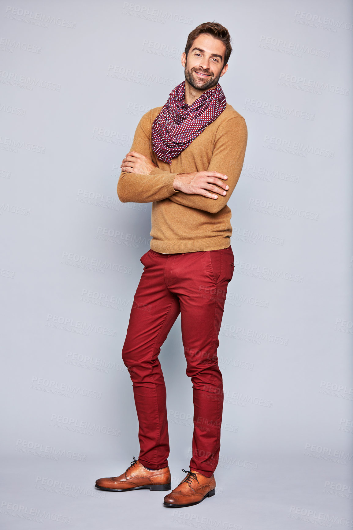 Buy stock photo Studio portrait of a handsome young man standing with his arms crossed against a grey background