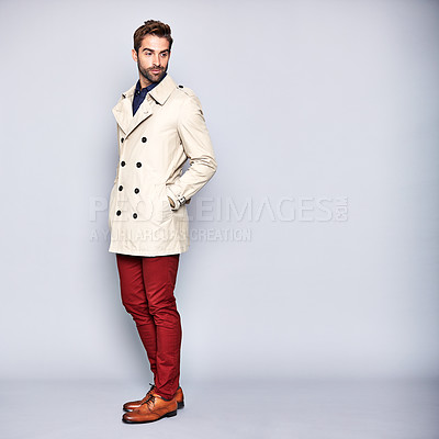 Buy stock photo Studio shot of a handsome young man posing in a trench coat against a grey background