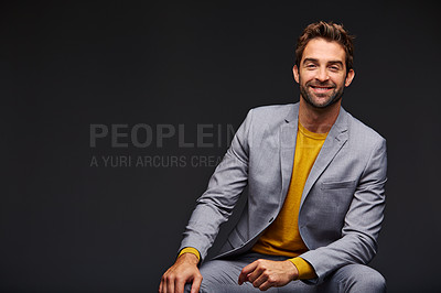 Buy stock photo Studio portrait of a handsome young businessman sitting against a grey background
