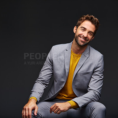 Buy stock photo Studio portrait of a handsome young businessman sitting against a grey background
