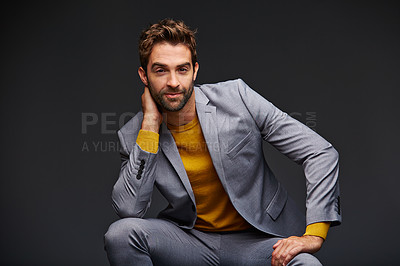 Buy stock photo Studio portrait of a handsome young businessman sitting against a grey background