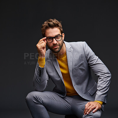 Buy stock photo Studio portrait of a handsome young businessman sitting against a grey background