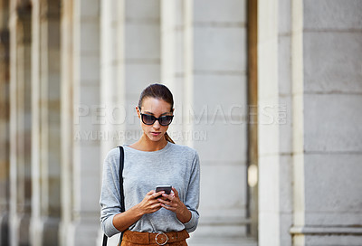Buy stock photo Cropped shot of a young woman walking through the city