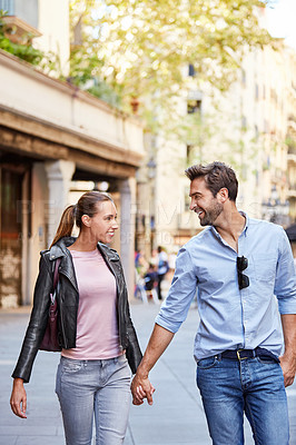 Buy stock photo Shot of an affectionate young couple exploring a foreign city