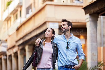 Buy stock photo Shot of an affectionate young couple exploring a foreign city