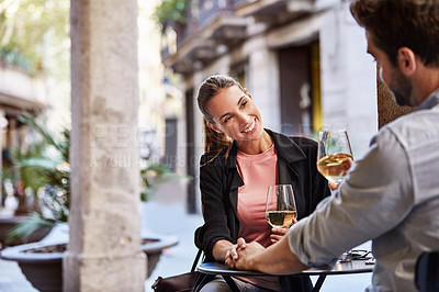 Buy stock photo Shot of a couple having wine outside at a restaurant