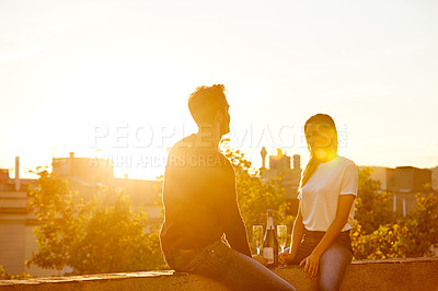 Buy stock photo Shot of a couple having drinks while on a rooftop date