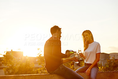 Buy stock photo Shot of a couple having champagne while on a rooftop date