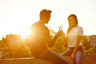 Buy stock photo Shot of a couple having champagne while on a rooftop date