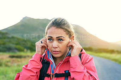 Buy stock photo Cropped shot of an attractive young female athlete listening to music while out for a morning run