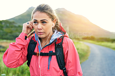 Buy stock photo Cropped shot of an attractive young female athlete listening to music while out for a morning run