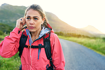 Buy stock photo Cropped shot of an attractive young female athlete listening to music while out for a morning run