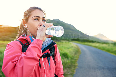 Buy stock photo Cropped shot of an attractive young female athlete drinking water while out for a morning run