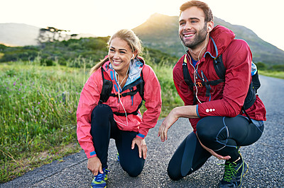 Buy stock photo Full length shot of a young couple tying their laces before a morning run