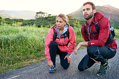 Buy stock photo Full length shot of a young couple tying their laces before a morning run