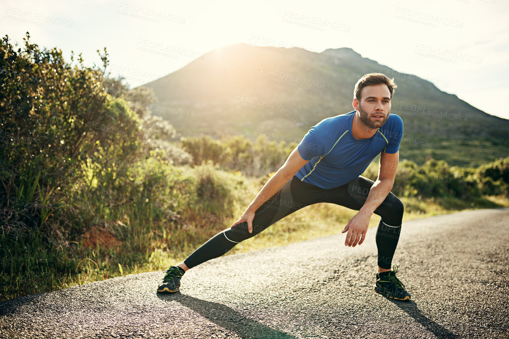 Buy stock photo Full length shot of a handsome young male athlete stretching before his run outdoors