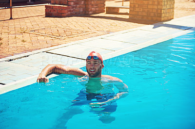 Buy stock photo High angle shot of a handsome young male swimmer leaning on the side of the pool during a swim