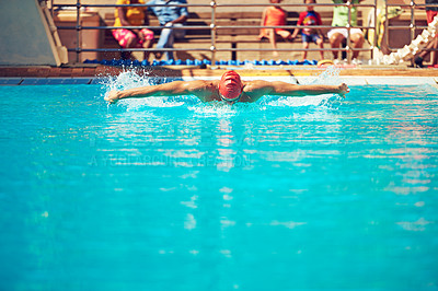 Buy stock photo Shot of an an unrecognizable young male swimmer practicing his technique in a large swimming pool