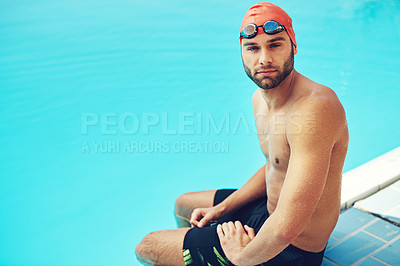 Buy stock photo High angle portrait of a handsome young male swimmer sitting on the side of a pool