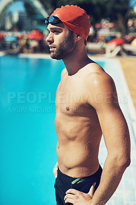 Buy stock photo Cropped shot of a handsome young male swimmer standing with his hands on his hips by the pool