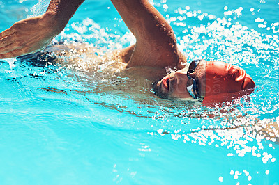 Buy stock photo Cropped shot of a handsome young male swimmer doing laps in a swimming pool