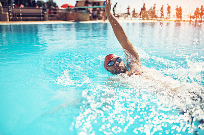 Buy stock photo Shot of a handsome young male swimmer doing backstroke in a swimming pool