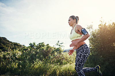 Buy stock photo Low angle shot of an attractive young female athlete out for a morning run
