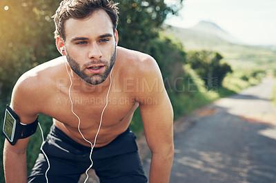 Buy stock photo Cropped shot of a handsome young male athlete looking tired during his morning run