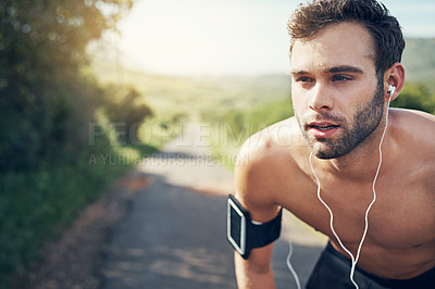 Buy stock photo Cropped shot of a handsome young male athlete looking tired during his morning run