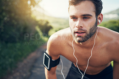 Buy stock photo Cropped shot of a handsome young male athlete looking tired during his morning run