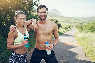 Buy stock photo Cropped portrait of an affectionate young couple taking fluids on board while out for their morning run