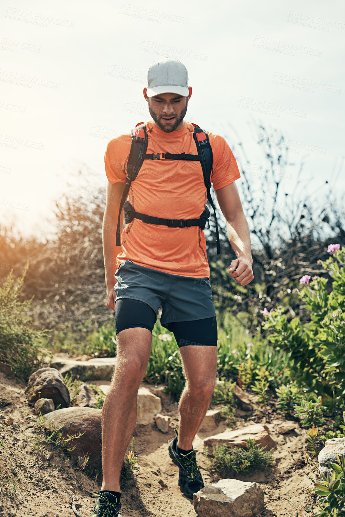 Buy stock photo Low angle shot of a handsome young male athlete out for a morning run