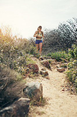 Buy stock photo Low angle shot of an attractive young female athlete out for a morning run