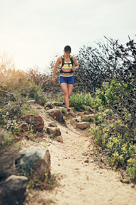 Buy stock photo Low angle shot of an attractive young female athlete out for a morning run