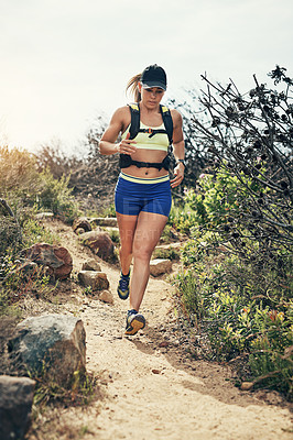 Buy stock photo Low angle shot of an attractive young female athlete out for a morning run