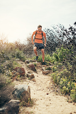 Buy stock photo Low angle shot of a handsome young male athlete out for a morning run