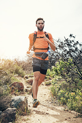 Buy stock photo Low angle shot of a handsome young male athlete out for a morning run