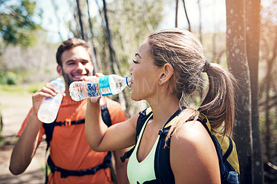 Buy stock photo Cropped shot of an affectionate young couple taking fluids on board while out for their morning run